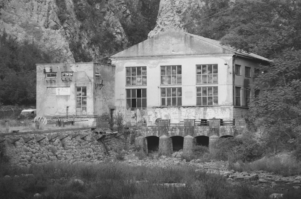 grayscale photo of house near trees