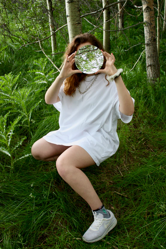 woman sitting on green grass at daytime