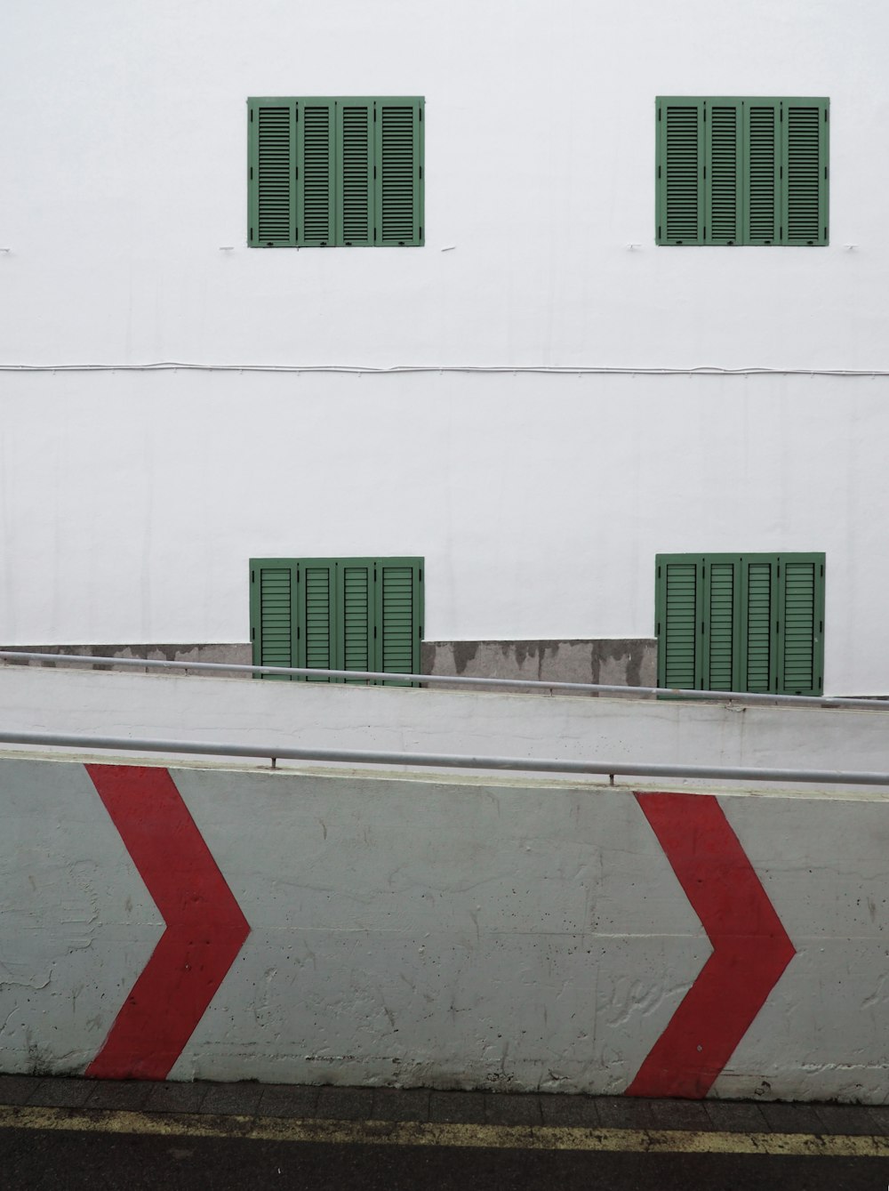 gray concrete railing with red painted arrows