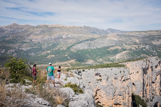 three people standing on cliff during daytime in Verdon Natural Regional Park France