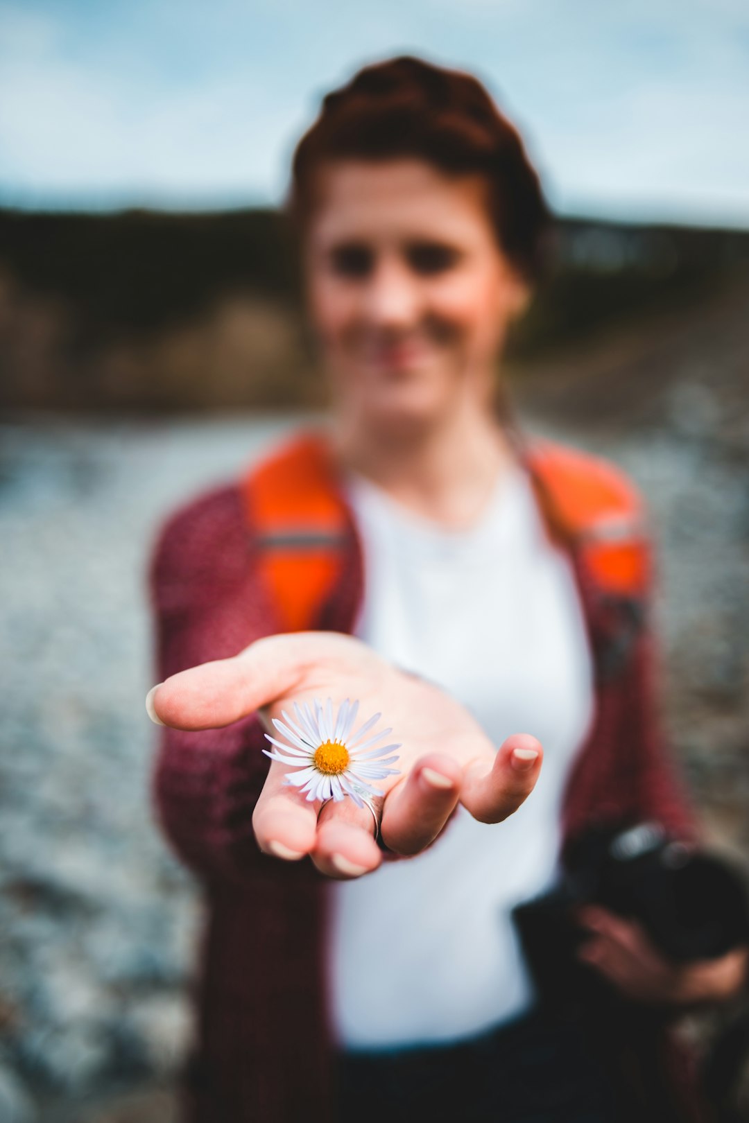 woman holds white petaled flower