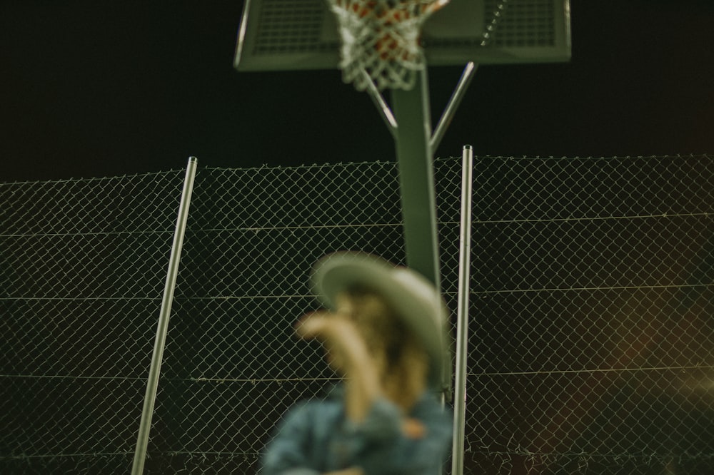 Photographie sélective de mise au point d’une femme portant un chapeau gris sur un terrain de basket-ball