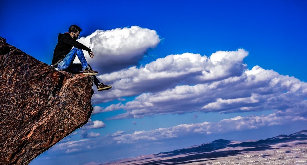 man sitting on cliff