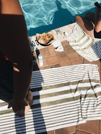 woman standing on towel near outdoor pool