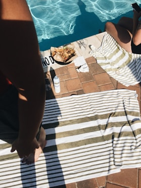 woman standing on towel near outdoor pool