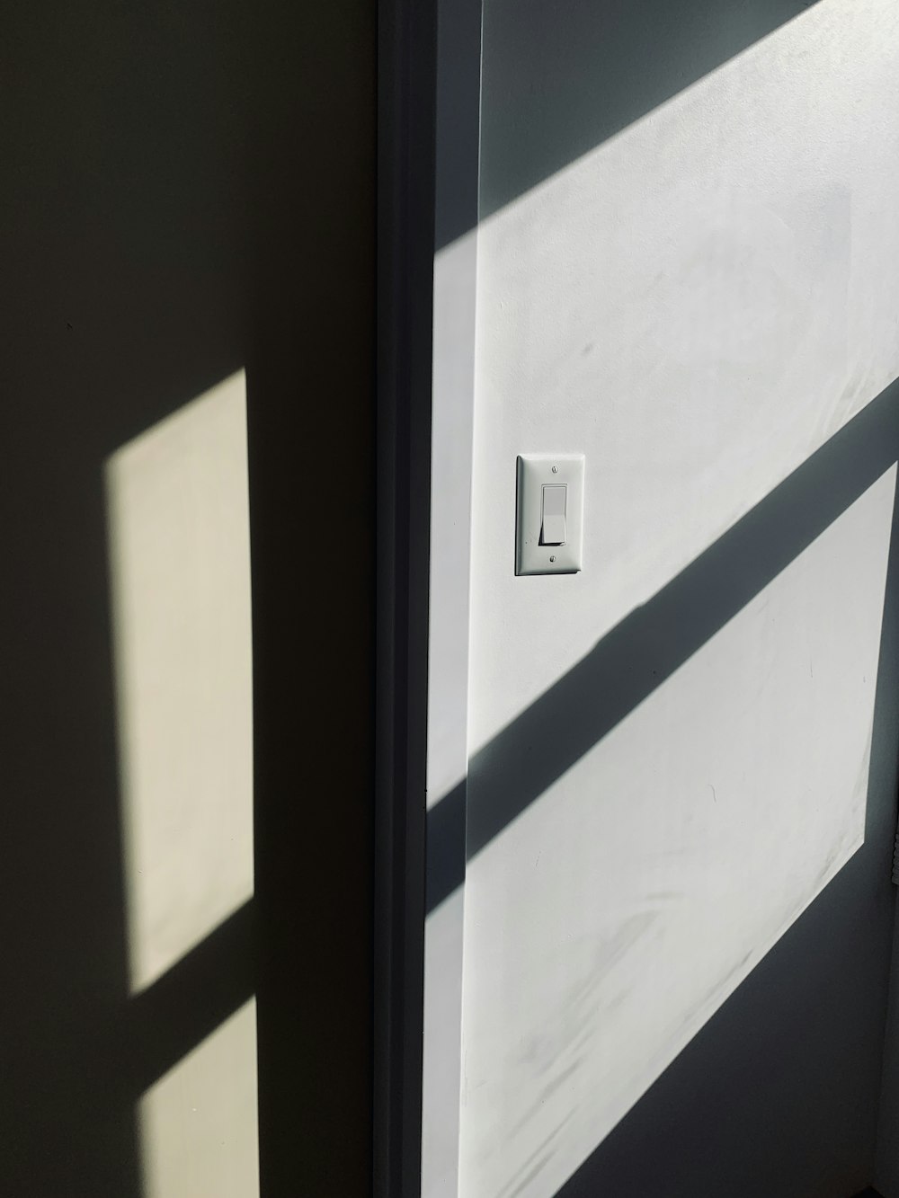 white wall switch besides door jamb