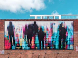 A group of artists installing a large-scale urban artwork on a vacant building wall in Brest