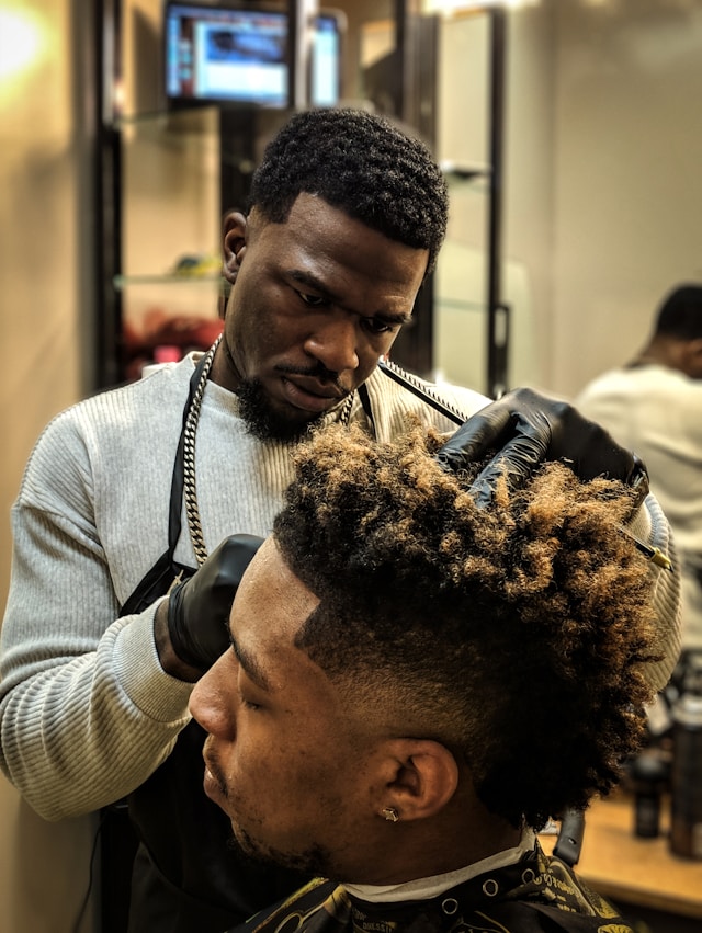 Barber cutting hair in barbershop