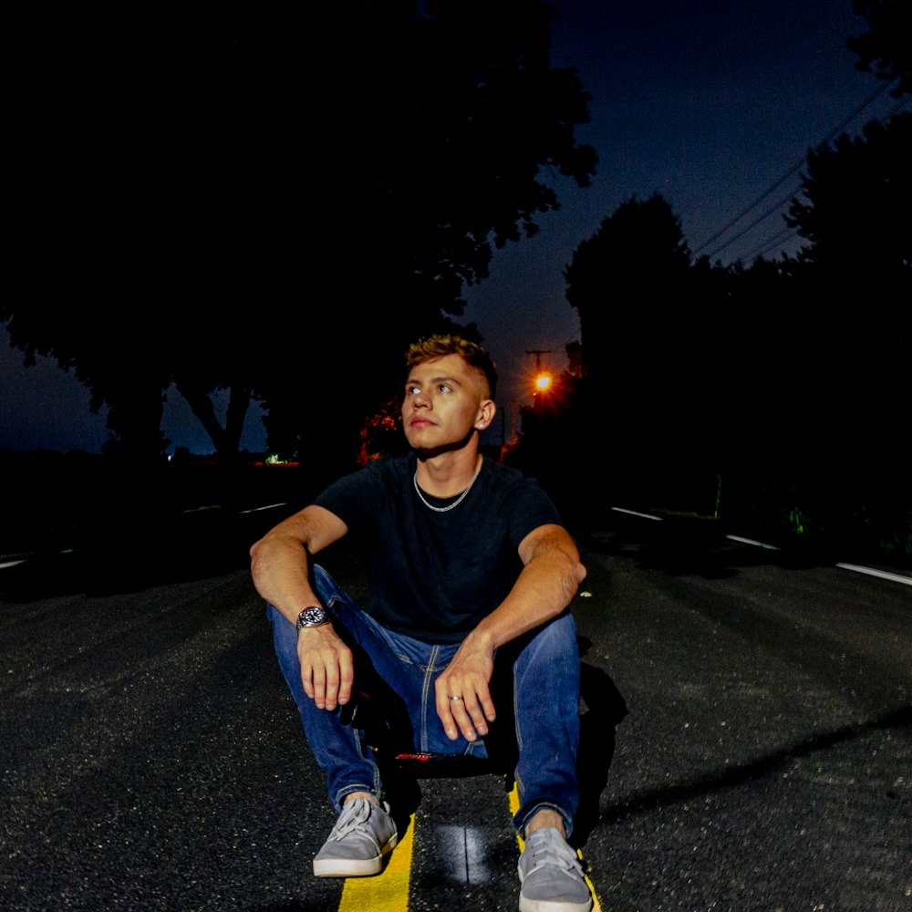 man sitting on paved road