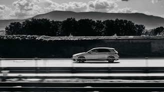 A dynamic shot of a car driving along a scenic road.