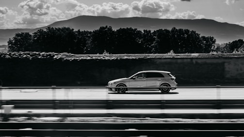 A dynamic shot of a car driving along a scenic road.