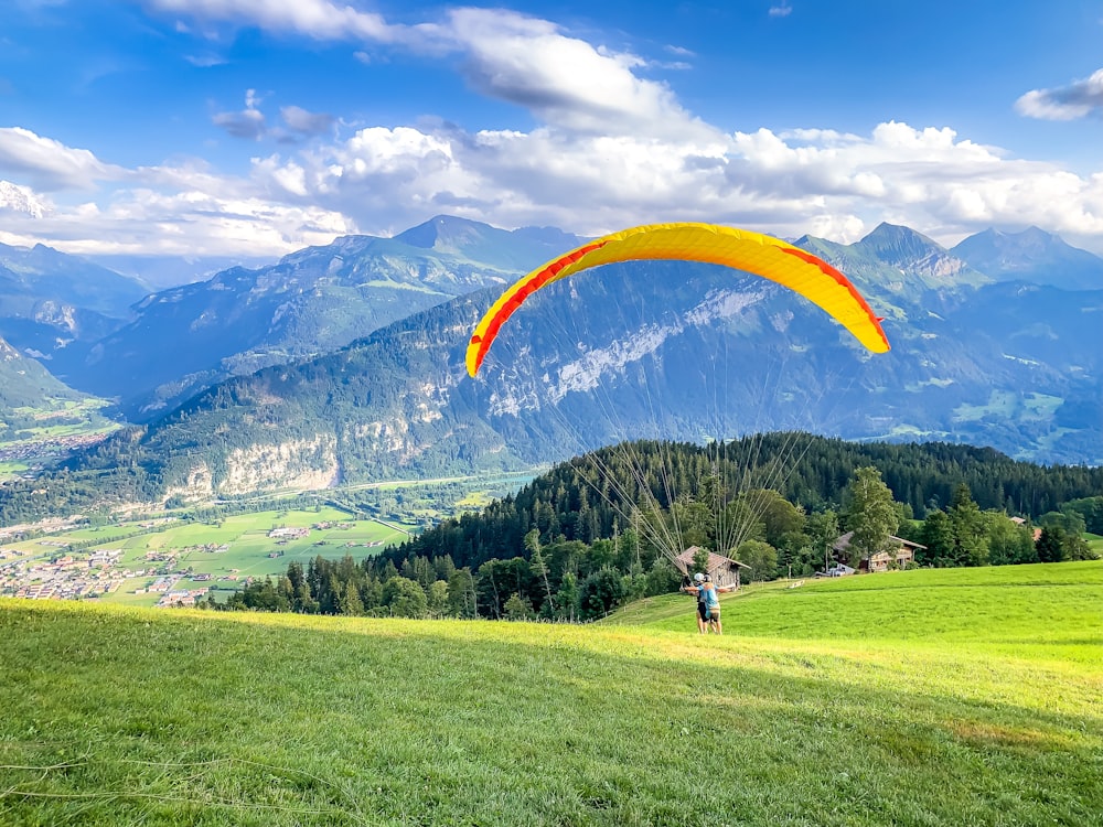 two men doing paragliding on the hill