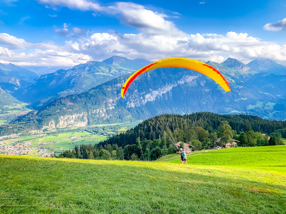 two men doing paragliding on the hill