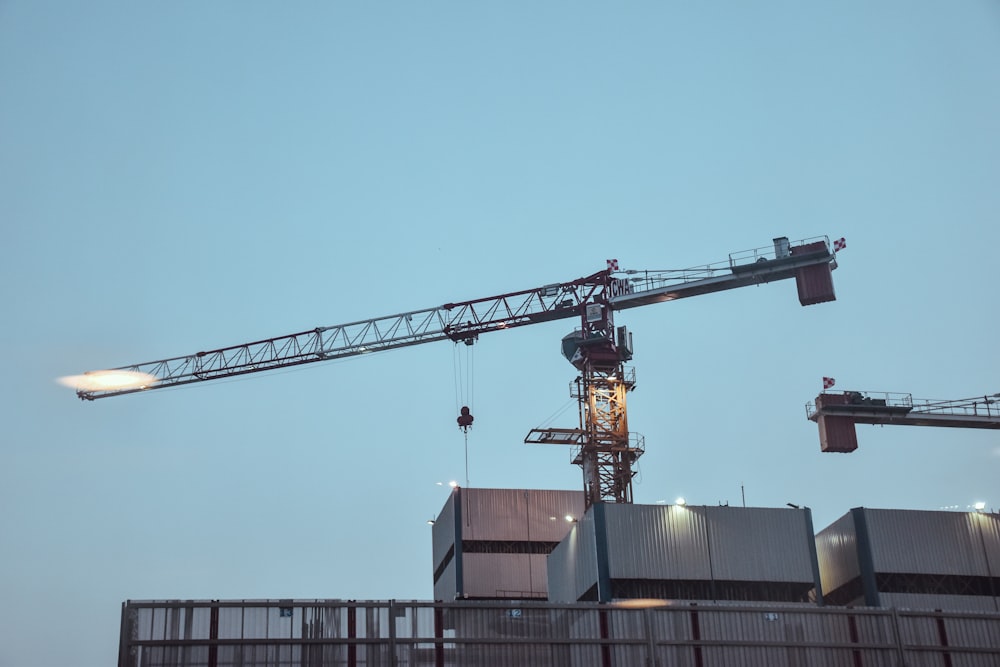 black steel industrial crane near concrete buildings