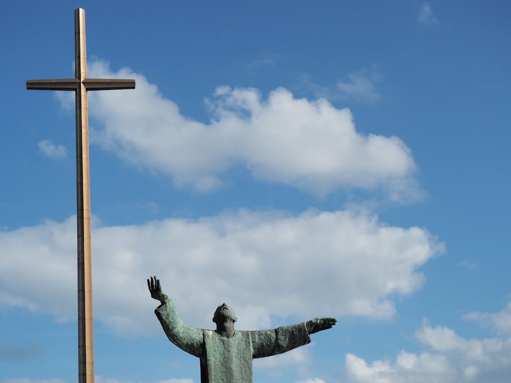man statue beside cross