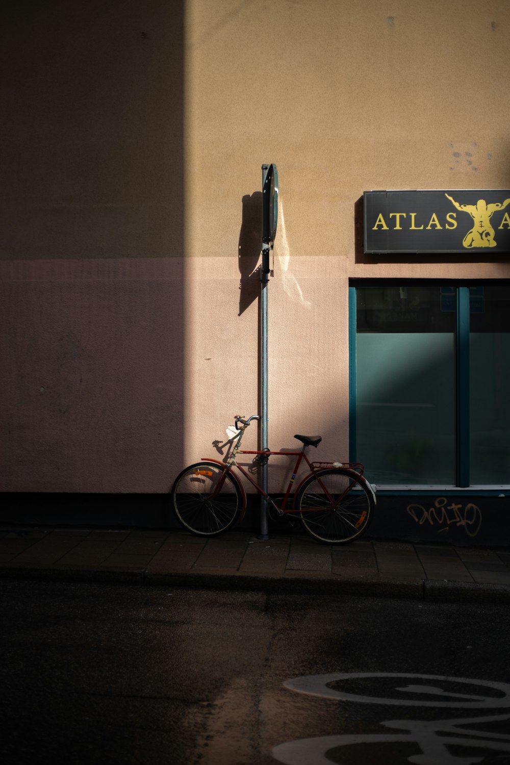 parked red bicycle beside pole