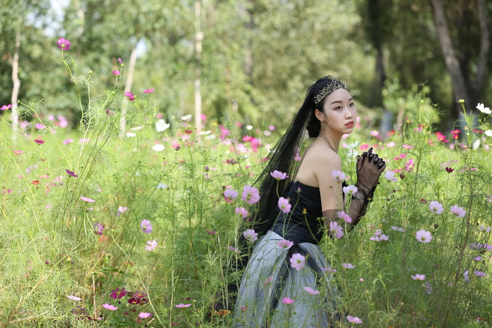 woman wearing black and grey dress standing on pink flower field