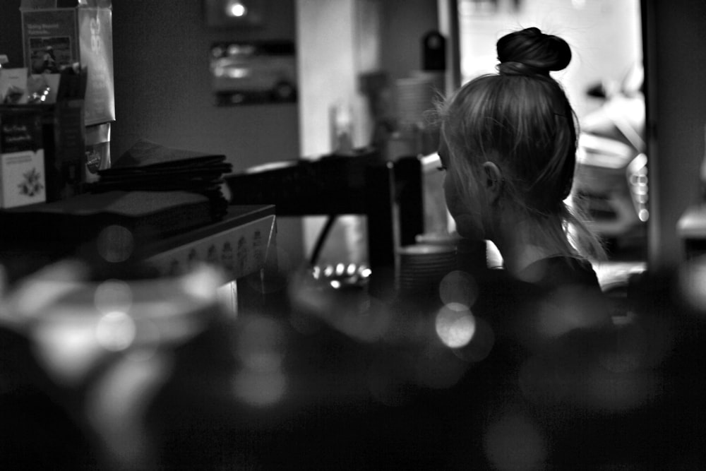 grayscale photography of woman standing near coffee maker