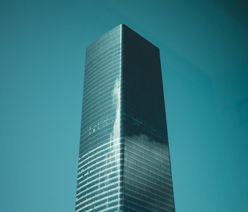 Photographie en contre-plongée d’un immeuble de grande hauteur en verre bleu