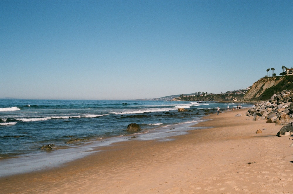 sand and rocky shore during day