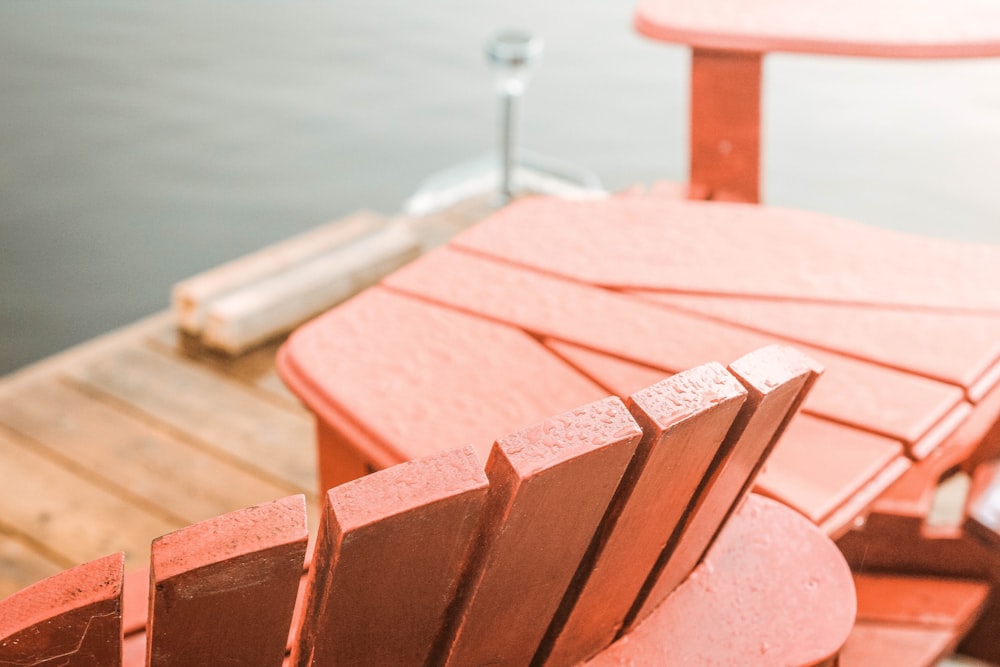 vacant pink wooden armless chair near body of water