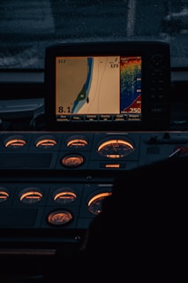 Close-up of a sleek marine GPS device mounted on a boat dashboard against a blue ocean backdrop