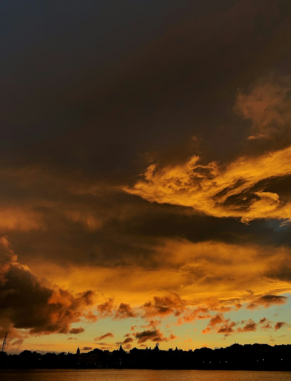 a plane flying over a body of water under a cloudy sky