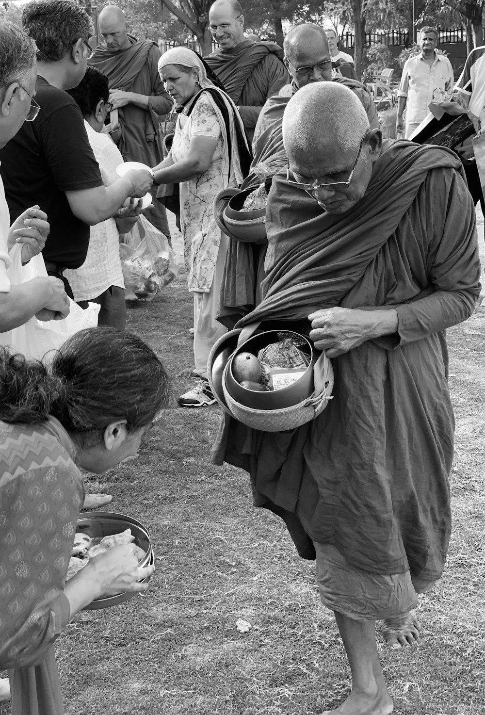 grayscale photo of man holding bowls beside woman