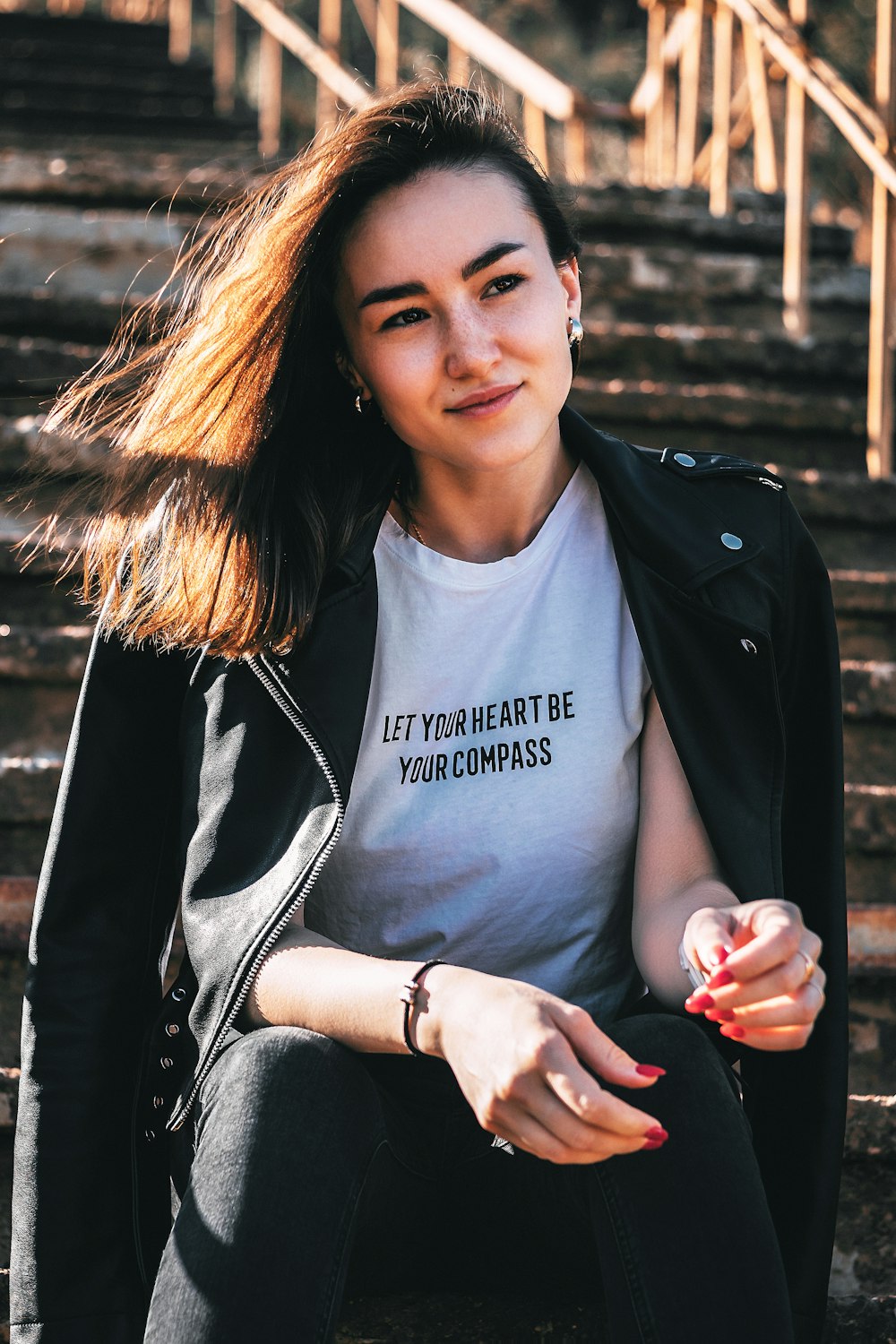 smiling woman wearing white shirt sitting on stair