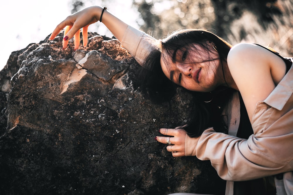 woman leans on the rock