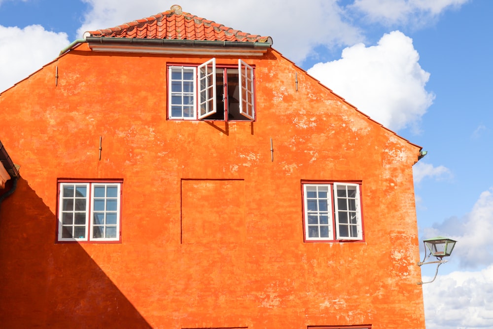 Edificio naranja con ventanas abiertas