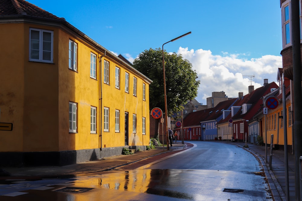 Gebäude am Bürgersteig mit Laternenpfählen und Schildern neben der Straße während des Tages