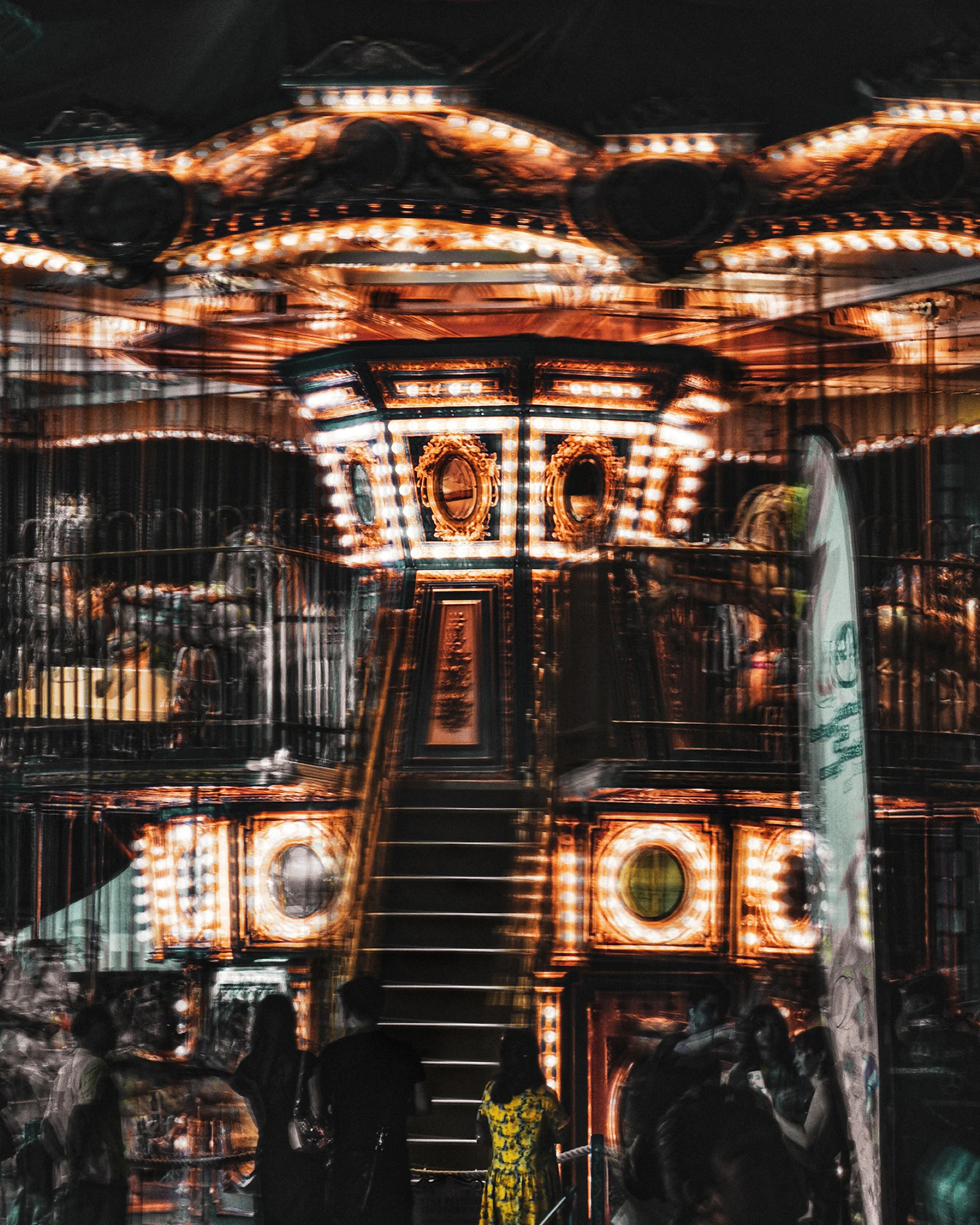 A long-exposure photo of a lit carousel spinning at night
