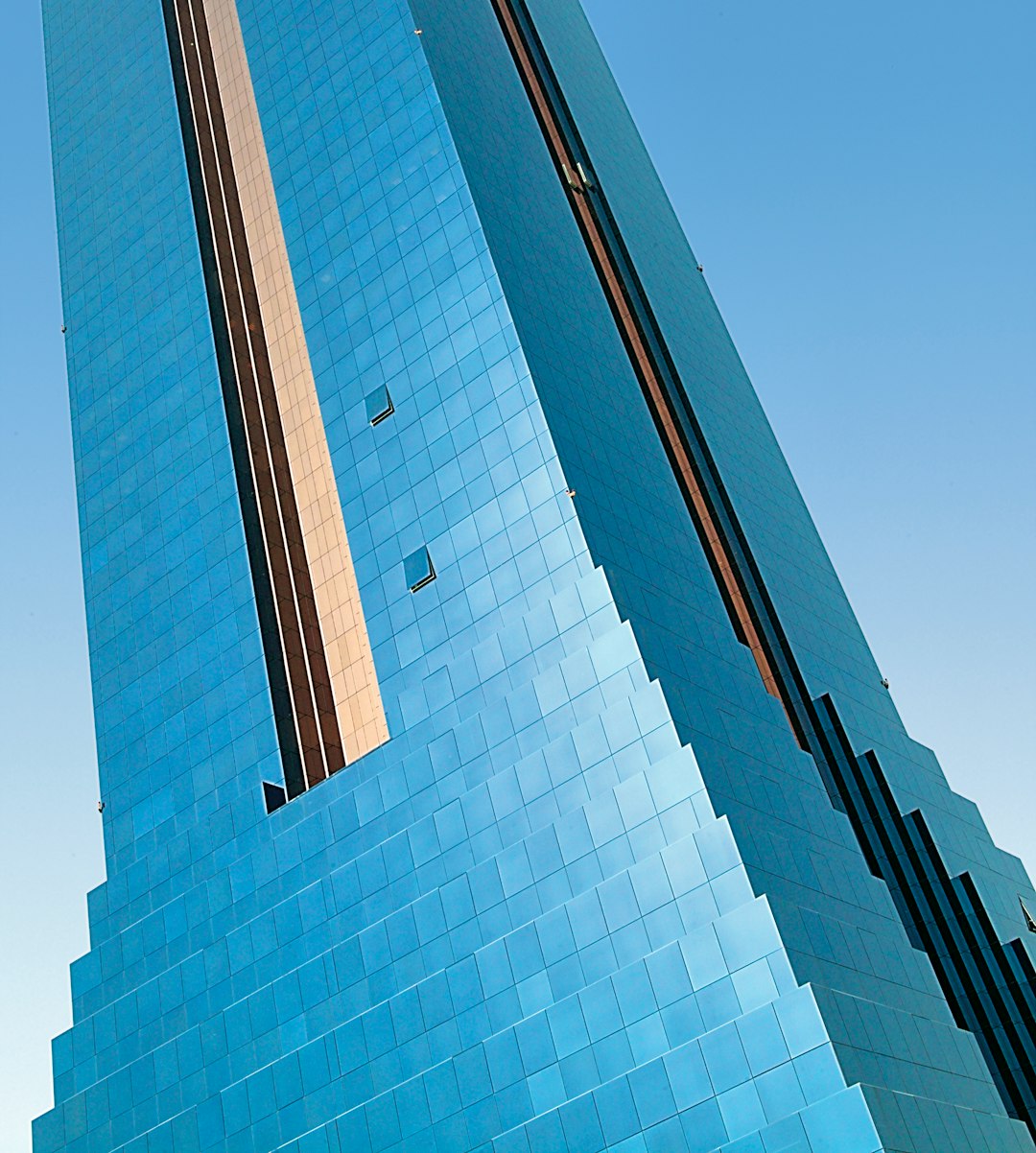blue glass walled high-rise tower building