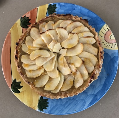 A warm, flaky apple turnover resting on a vintage plate.