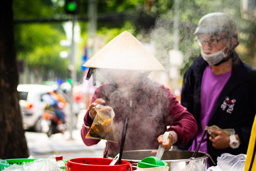 man standing beside vendor preparing food