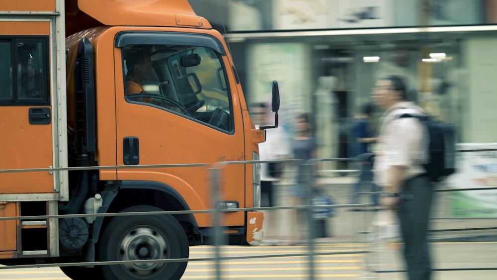 person standing near orange truck