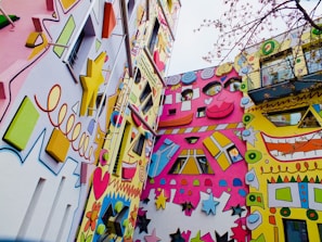 An exterior wall being painted with vibrant colors.