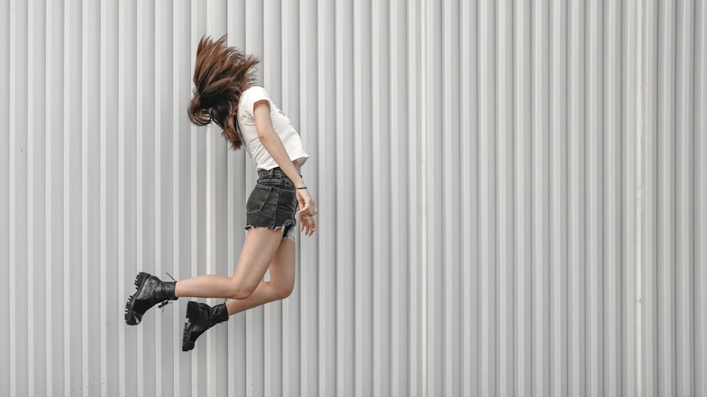 woman jumping beside wall