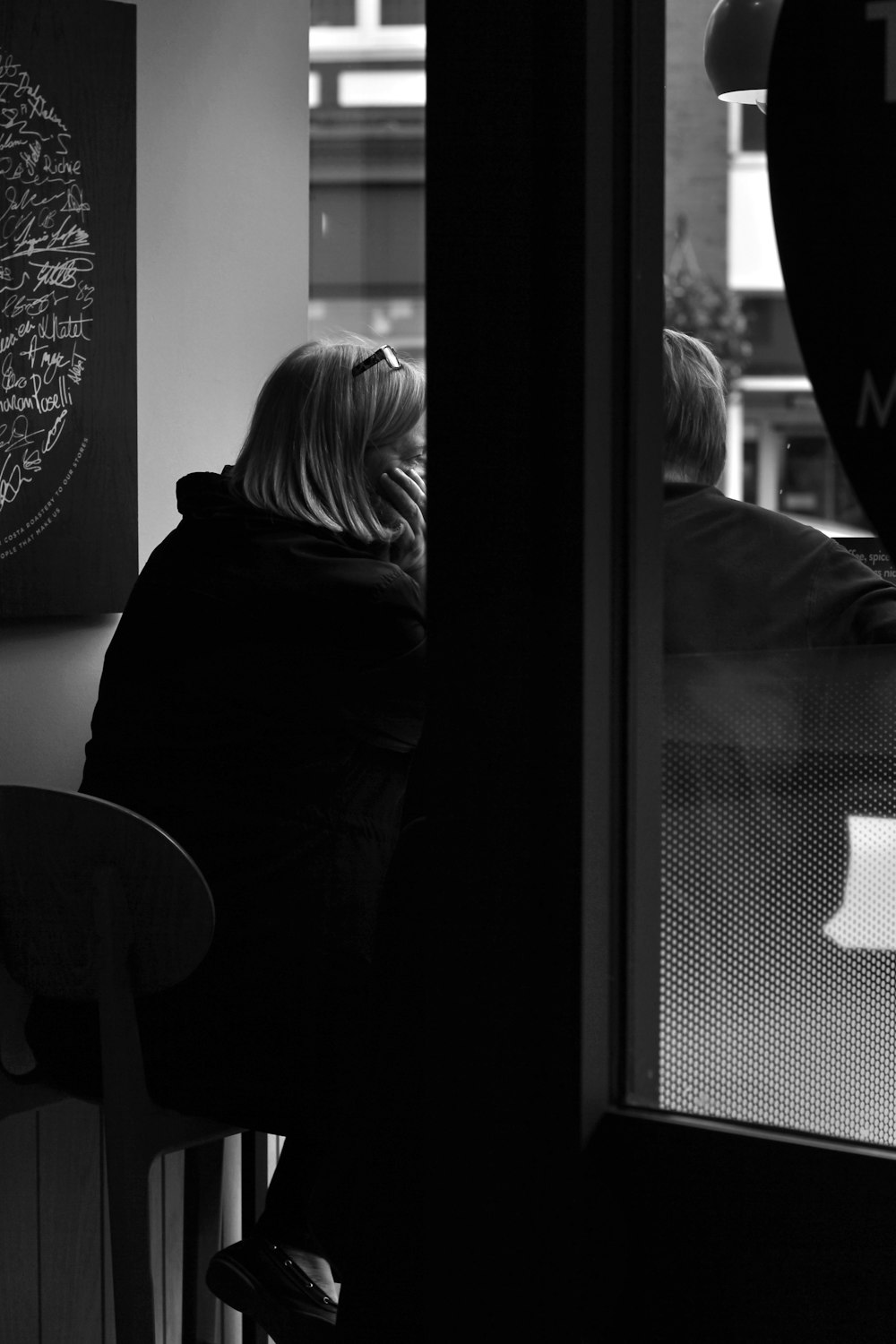 a woman sitting at a table looking out a window