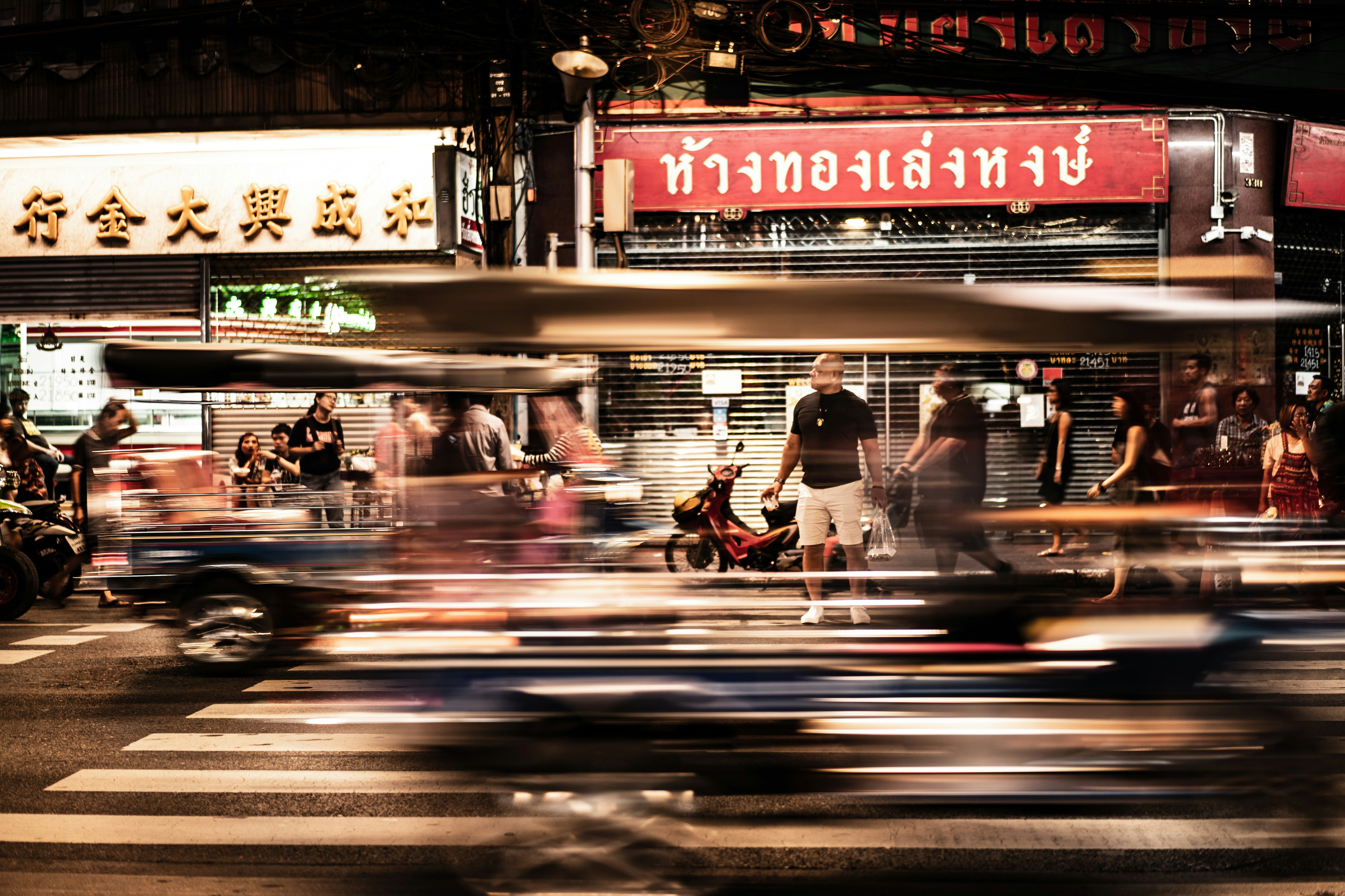 time lapse photography of vehicles passing on road in front of store