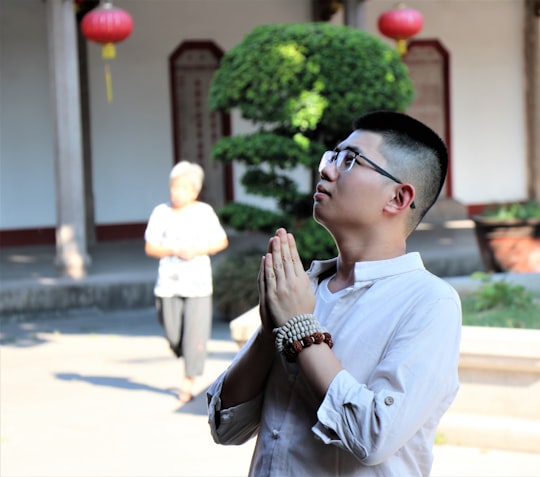 man wearing gray dress shirt both hands clasps looking up during daytime in Shantou China
