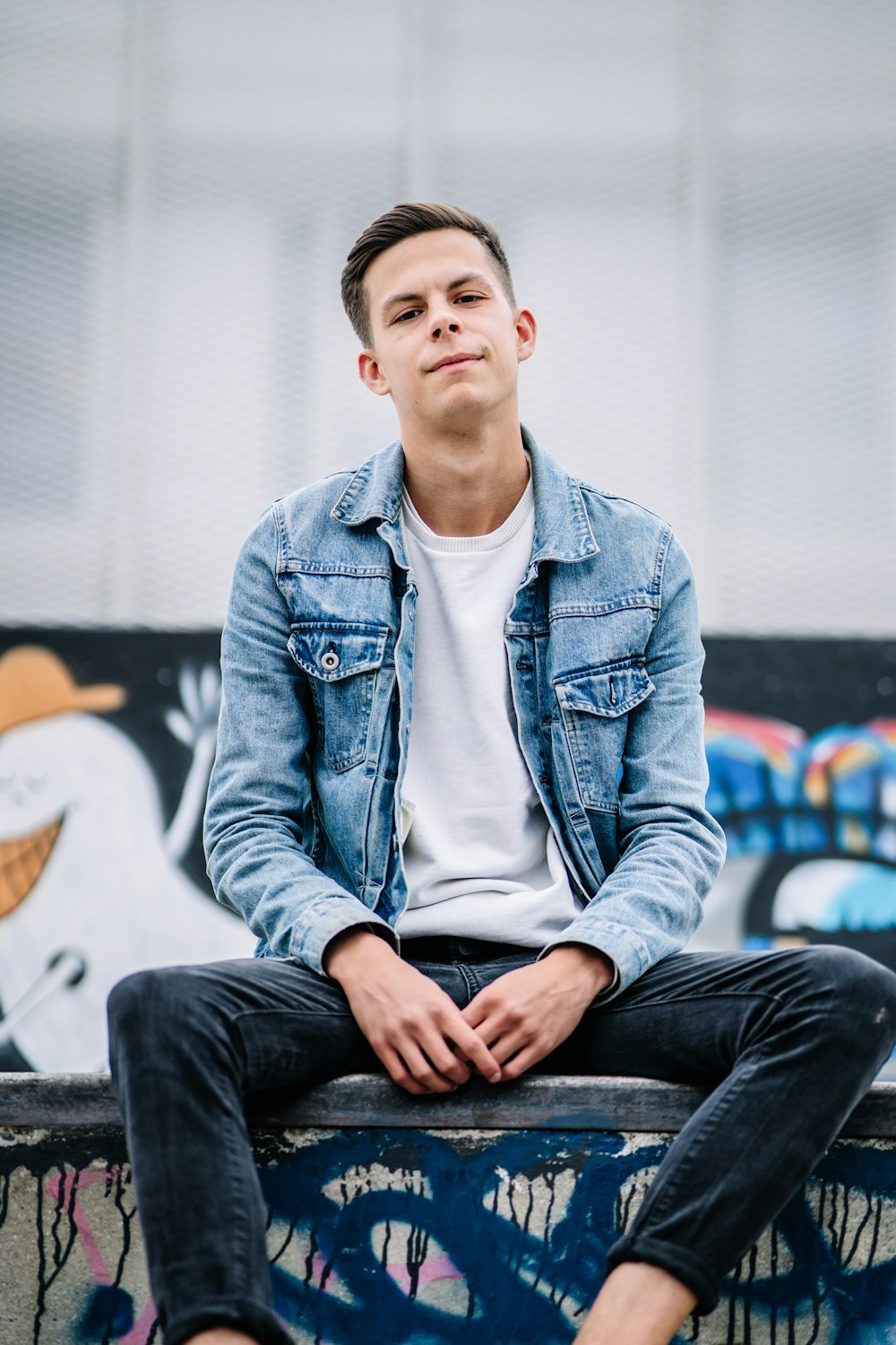 man wearing white crew-neck shirt and blue faded denim jacket