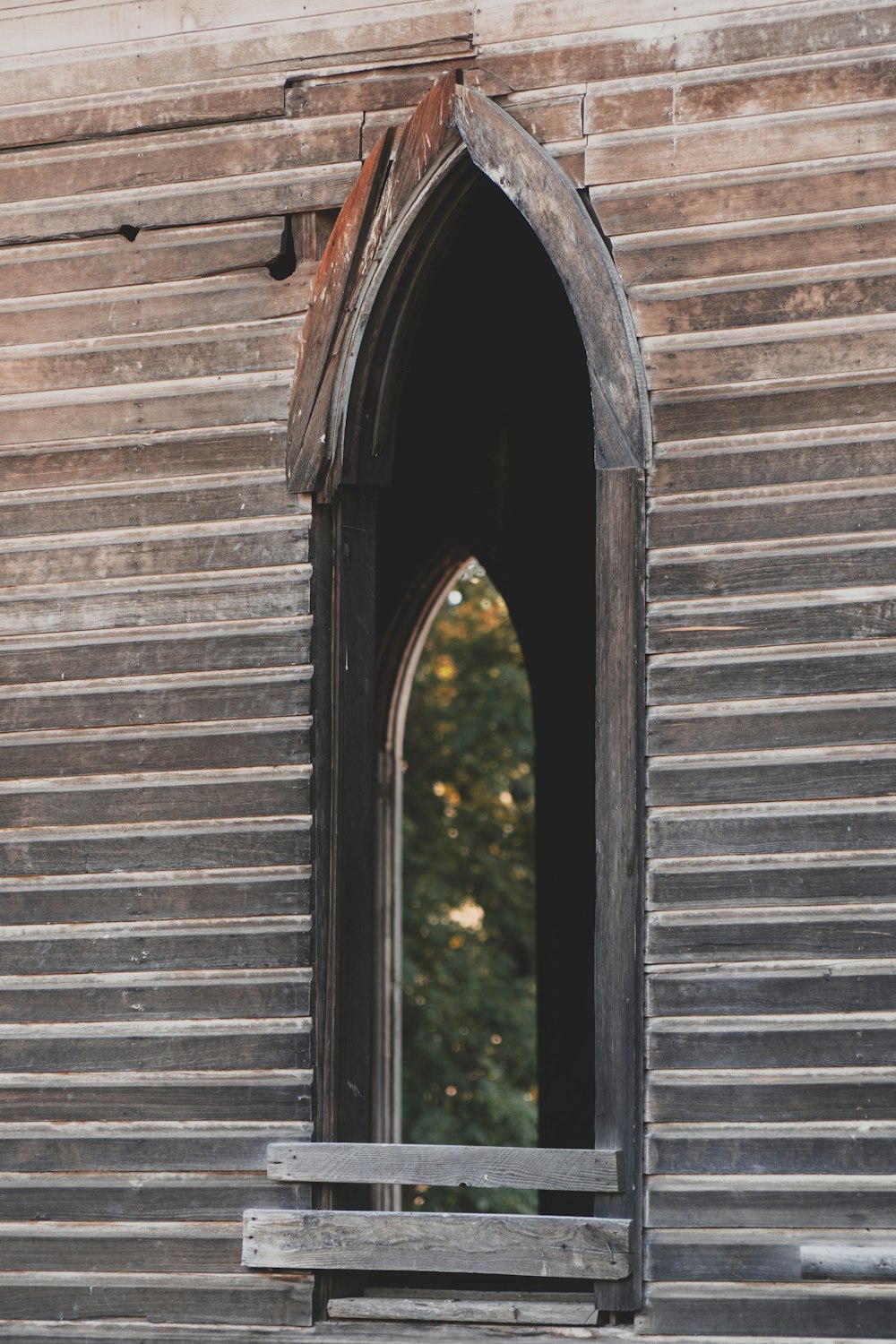 a wooden bench sitting in front of a window