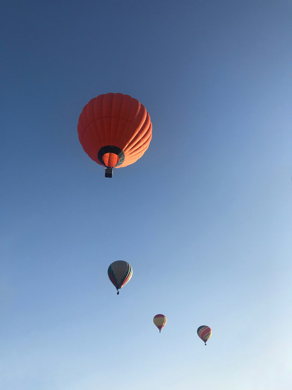 four hot air balloons in mid air during daytime
