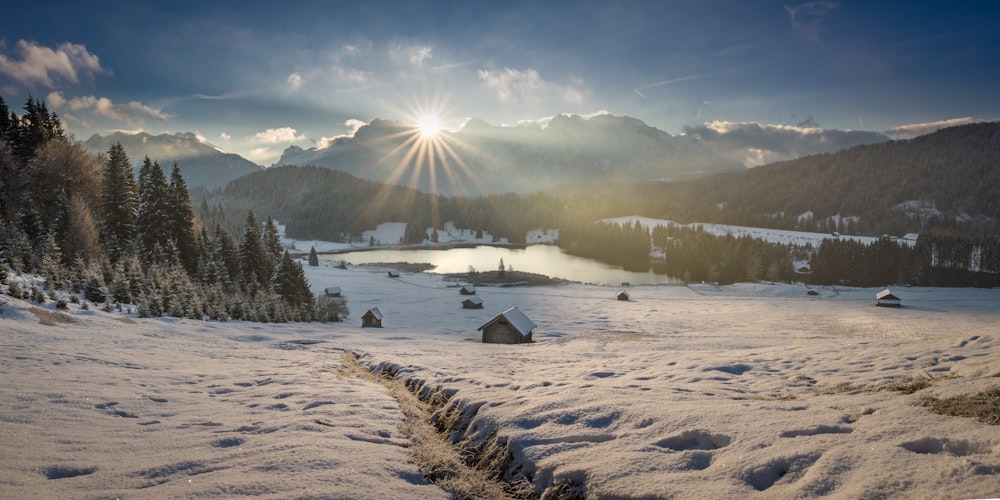 the sun is shining over a snowy mountain range