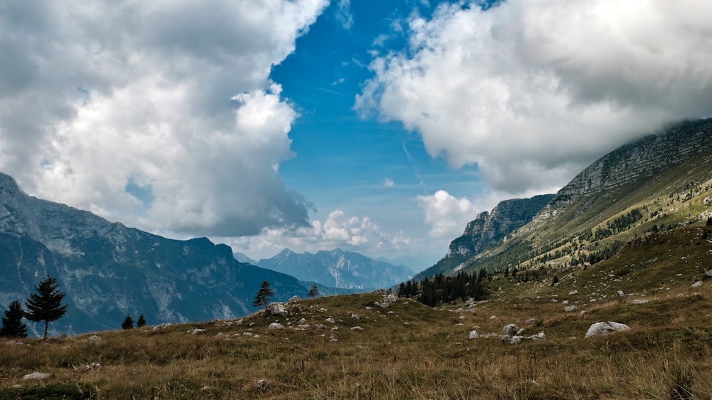 collines brunes sous des nuages blancs pendant la journée