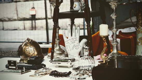 A cozy arrangement of vintage collectibles, home décor, and fashion items displayed invitingly on a rustic wooden table.