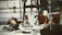 A collection of antique and vintage items displayed on a table, including a brass helmet, a palmistry hand model, various candlesticks, and a selection of small decorative objects. The scene gives a sense of eclectic charm and nostalgia.