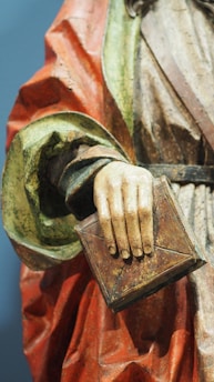 a close up of a statue of a person holding a book